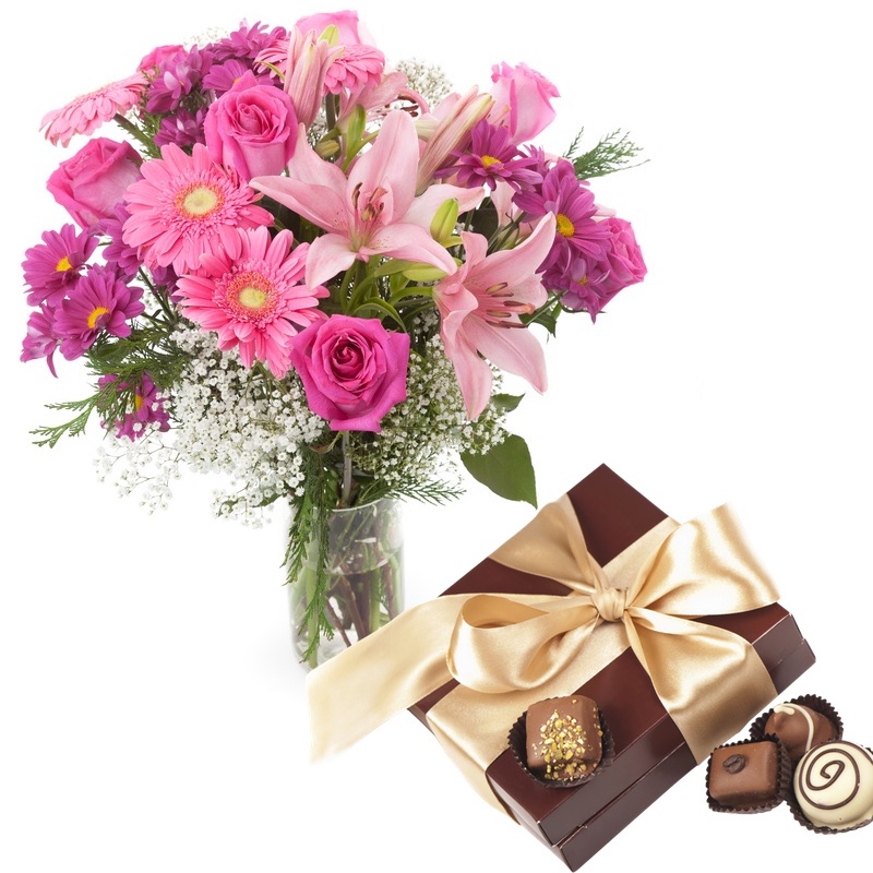 pink lilies gerberas roses in vase with chocolates